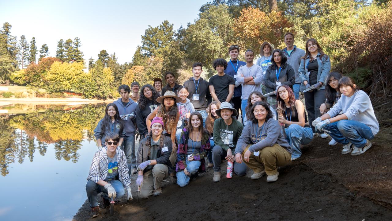 A group of volunteers pose on the banks of the Arboretum Waterway