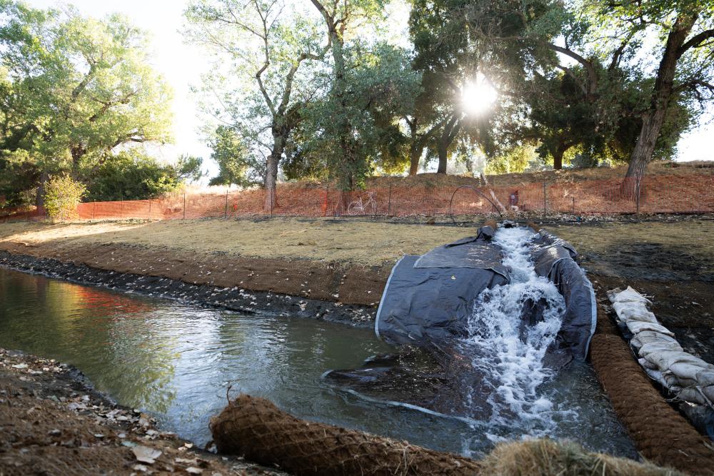 Image of water being released into a narrow channel of the Arboretum Waterway.